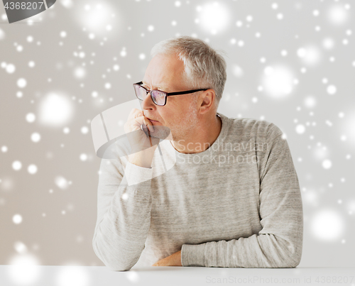 Image of close up of senior man in glasses thinking