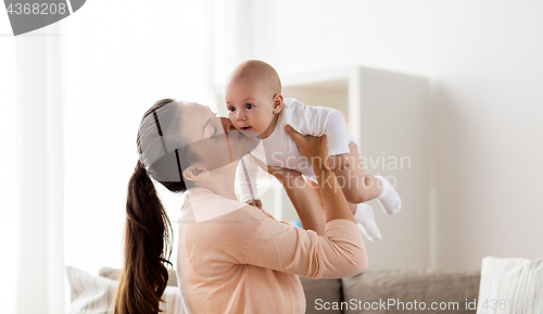 Image of happy mother kissing little baby boy at home