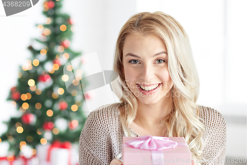 Image of happy young woman with gift box at christmas