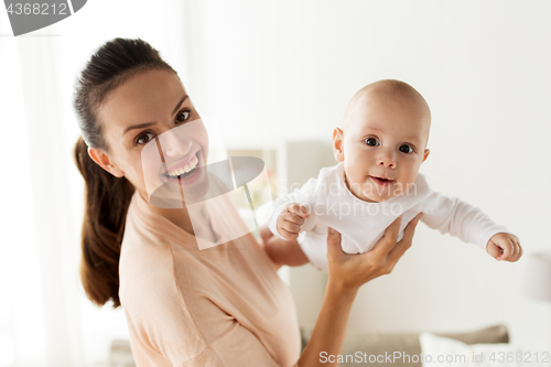 Image of happy mother playing with little baby boy at home