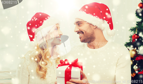 Image of happy couple at home with christmas gift box