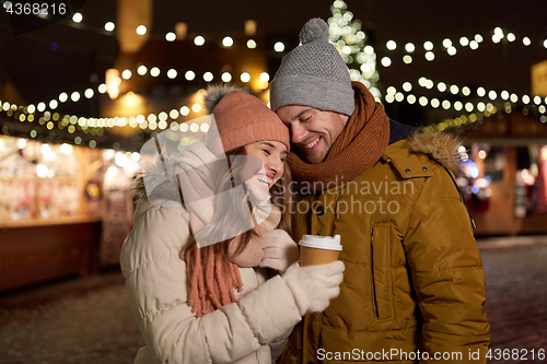 Image of happy young couple with coffee at christmas market