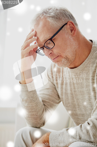 Image of senior man suffering from headache at home