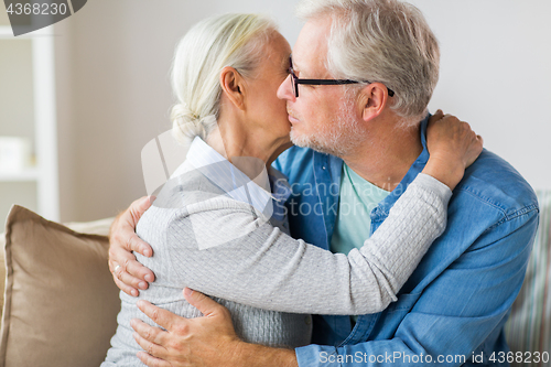 Image of close up of happy senior couple hugging at home