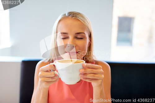 Image of close up of woman drinking coffee at restaurant