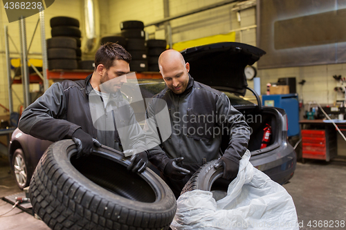 Image of auto mechanics changing car tires at workshop