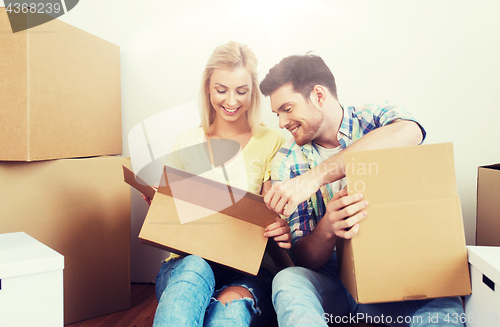 Image of smiling couple with many boxes moving to new home