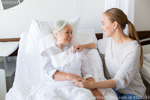 Image of daughter visiting senior mother at hospital