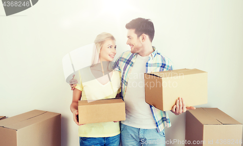 Image of smiling couple with big boxes moving to new home