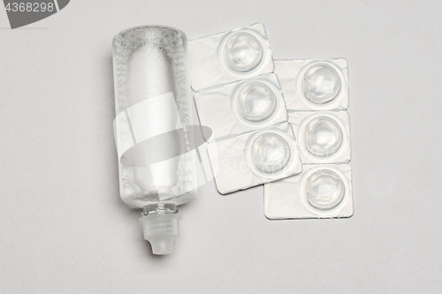 Image of Contact lens solution and contact lens packages on white background
