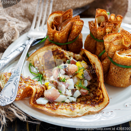 Image of Pancake pouches filled with herring, eggs and greens.