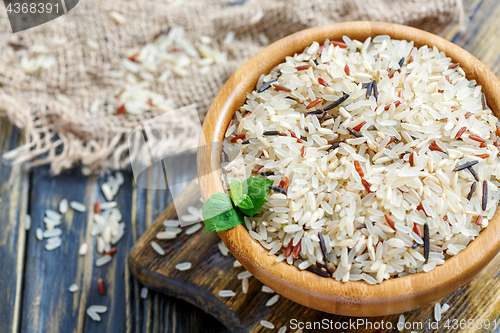 Image of Red, white, brown and wild rice in a wooden bowl closeup.