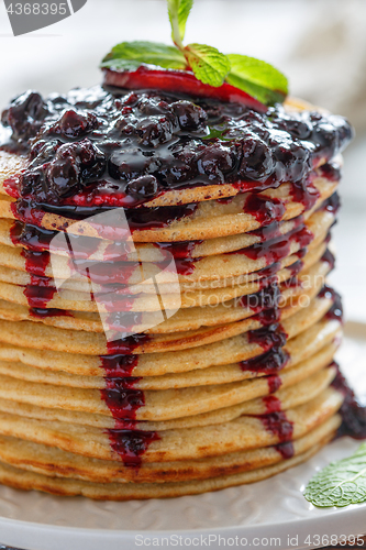 Image of Pancakes with berry sauce and mint close-up.