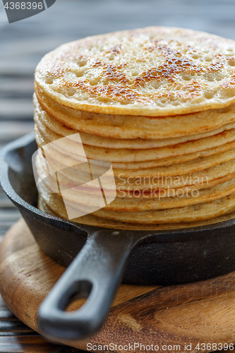 Image of Cast iron pan with stack of fresh pancakes