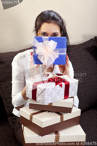 Image of girl holds one of the many gift boxes
