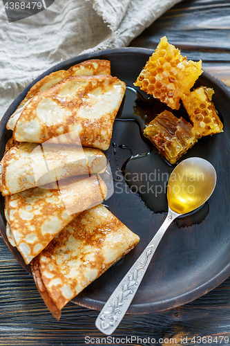 Image of Crepes and honey for a delicious breakfast.