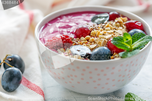 Image of Healthy smoothie bowl with red beets and black grapes.