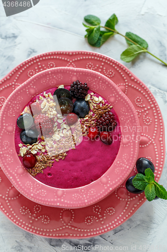 Image of Red smoothie bowl with beets, blackberries and brown flax.