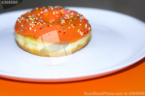 Image of Appetizing donut decorated with orange glaze
