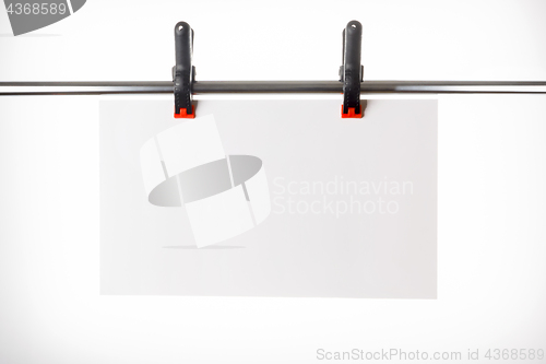 Image of White plate hanging on pins