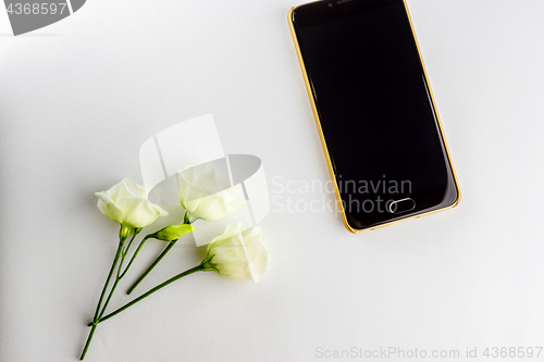 Image of Small flowers and modern stylish smartphone