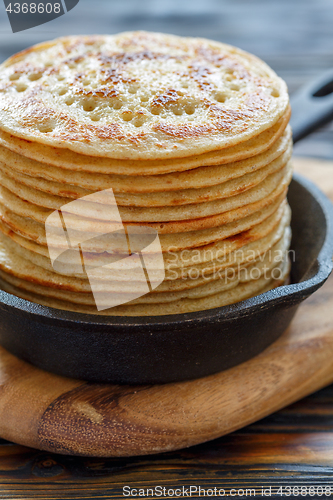 Image of Cast iron pan with stack of fresh pancakes