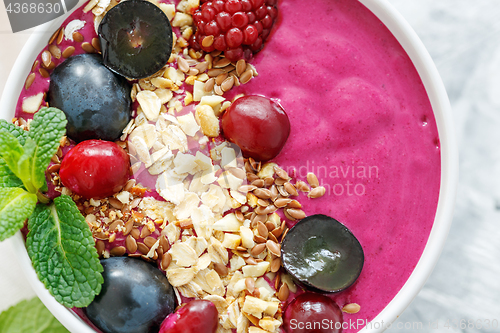 Image of Red smoothie bowl with beets and black grapes.