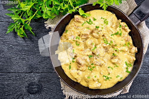 Image of Meat stewed with cream in pan on board top