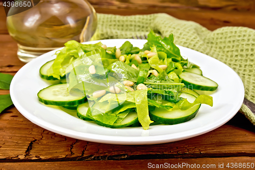 Image of Salad from spinach and cucumber with napkin on board