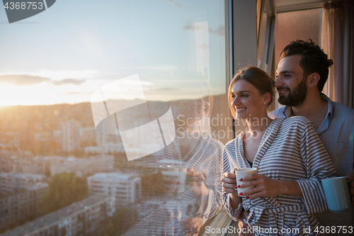 Image of young couple enjoying evening coffee by the window