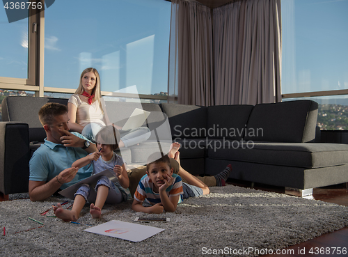 Image of young couple spending time with kids at home