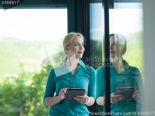 Image of young women using tablet computer by the window