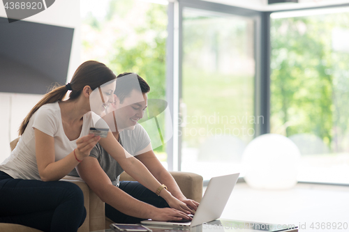 Image of happy young couple buying online