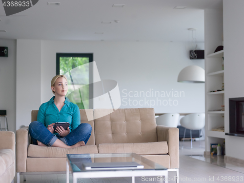Image of woman on sofa using tablet computer