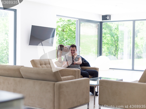 Image of couple relaxing at  home with tablet computers