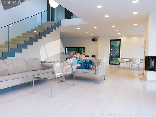 Image of young happy couple relaxes in the living room