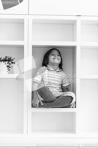 Image of young boy posing on a shelf