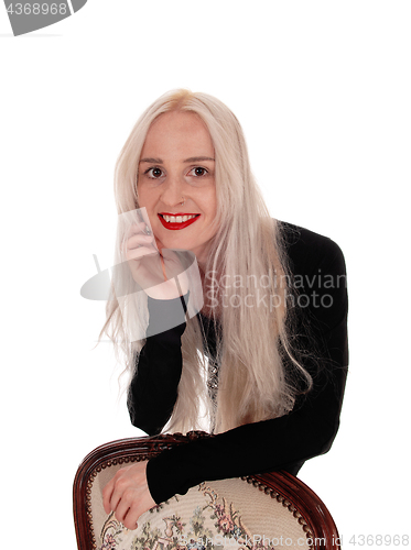 Image of Woman bending over old armchair
