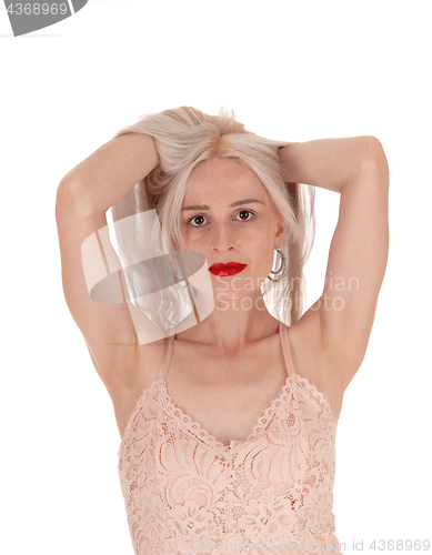 Image of Woman messing up her long blond hair