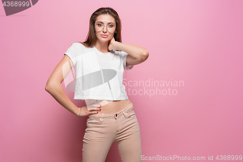 Image of Pretty young sexy fashion sensual woman posing on pink background dressed in hipster style jeans