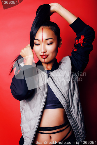 Image of young pretty asian girl posing cheerful on red background, fashion style makeup and hair, lifestyle modern orient people concept