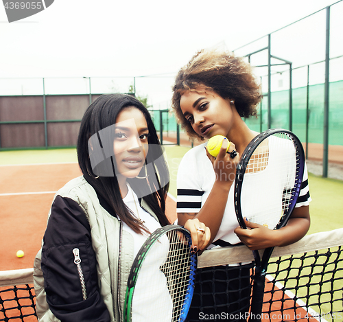 Image of young pretty girlfriends hanging on tennis court, fashion stylis