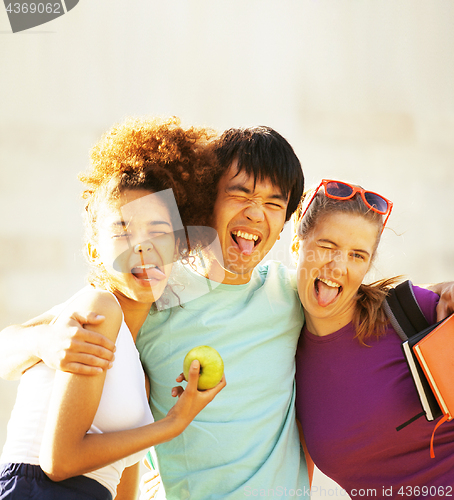 Image of cute group of teenages at the building of university with books 