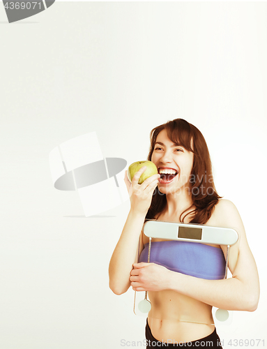 Image of portrait of young smiling girl with green apple and scales