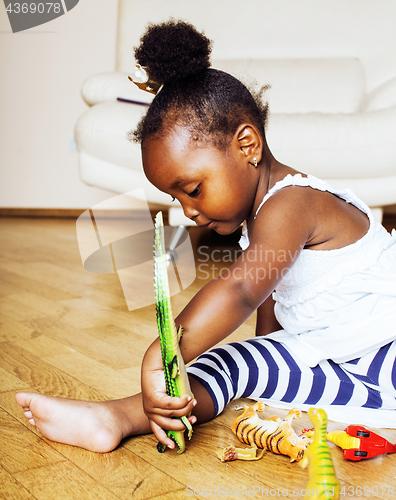 Image of little cute african american girl playing with animal toys at ho