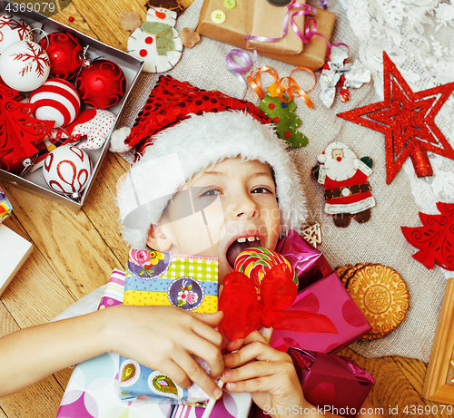 Image of little cute boy with Christmas gifts at home. close up emotional