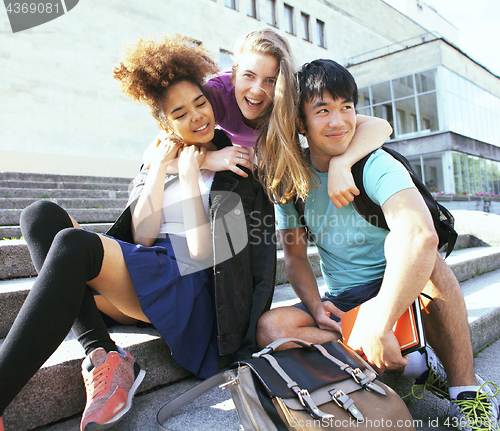 Image of cute group teenages at the building of university with books huggings, back to school