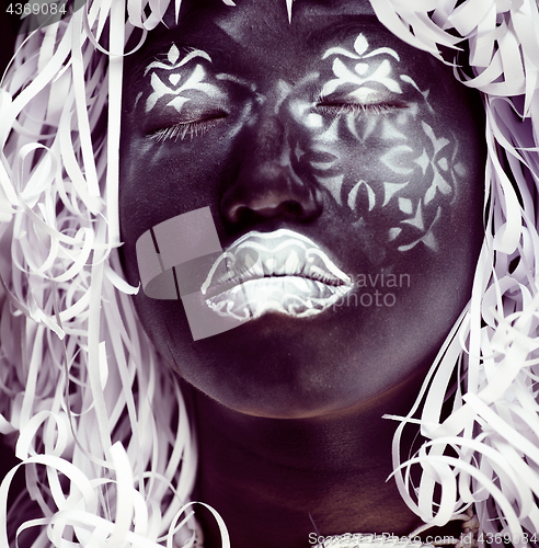 Image of creative makeup like Ethiopian mask, white pattern on black face