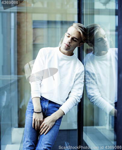 Image of young modern hipster guy at new building university blond fashion hairstyle having fun, lifestyle people concept 
