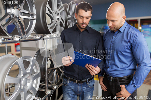 Image of customer and salesman at car service or auto store